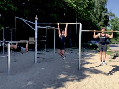 Mænd laver armhævninger i udendørs CrossFIT styrketræningsanlæg